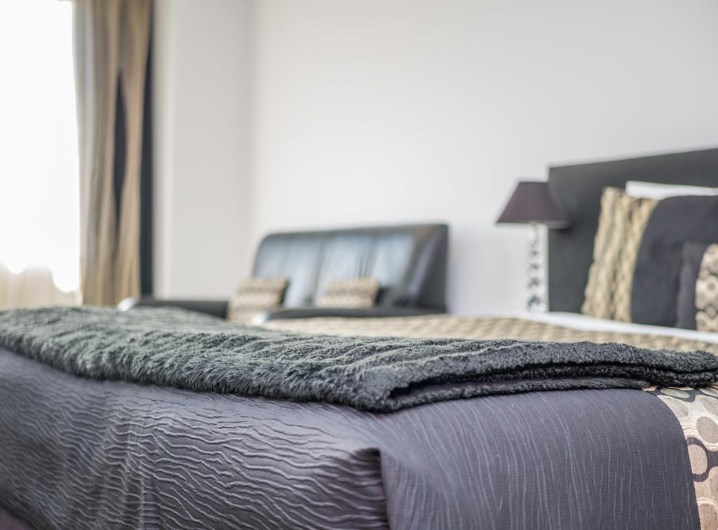 Bellano Motel Suites Christchurch Exterior foto A bed with a throw